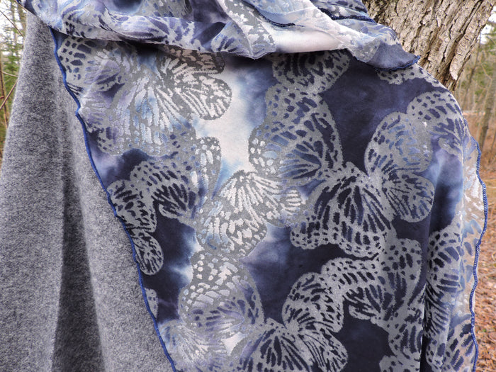 Close-up of a blue and gray patterned fabric with a natural background